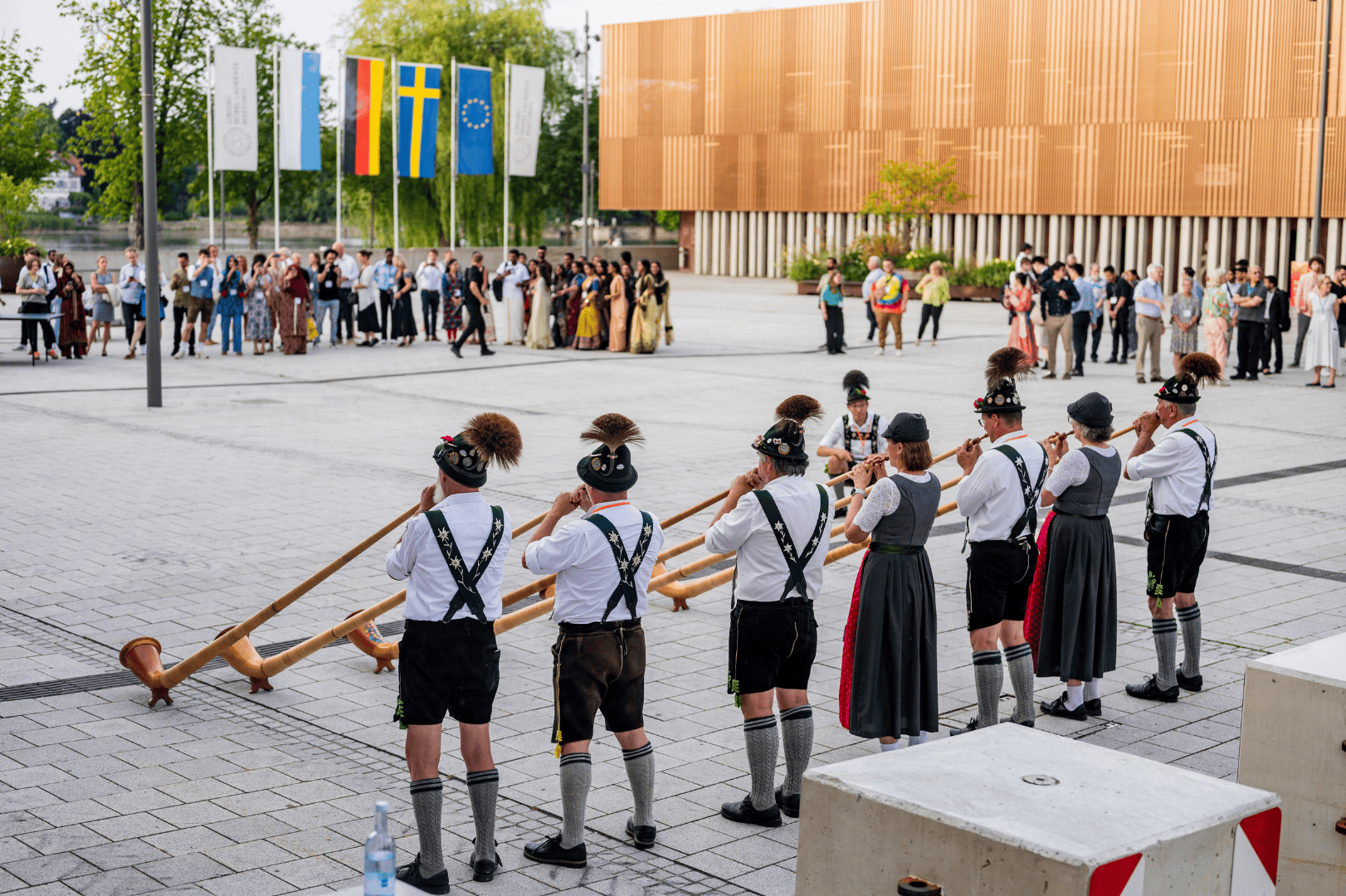 Six people in Traditional dress play the Bavarian Alphorn for Lindau meeting attendees.